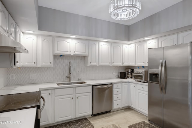 kitchen with white cabinets, sink, appliances with stainless steel finishes, and an inviting chandelier