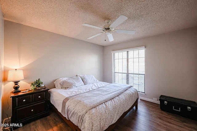 bedroom featuring ceiling fan, dark hardwood / wood-style floors, and a textured ceiling