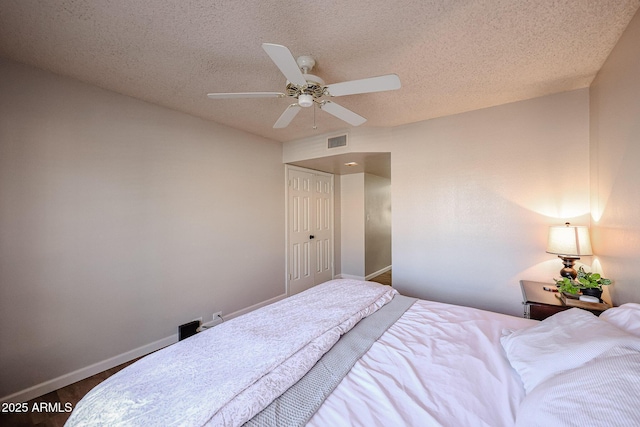 bedroom with ceiling fan and a textured ceiling