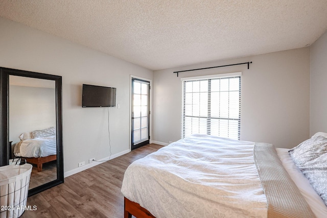 bedroom featuring a textured ceiling and dark hardwood / wood-style flooring