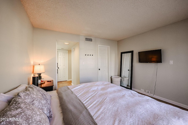 bedroom featuring a textured ceiling and wood-type flooring