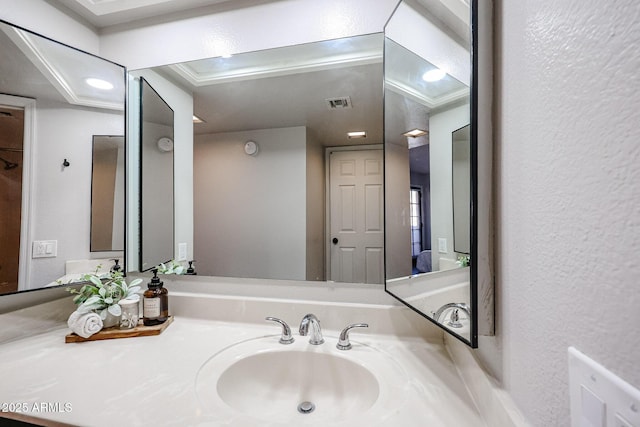 bathroom with crown molding and vanity