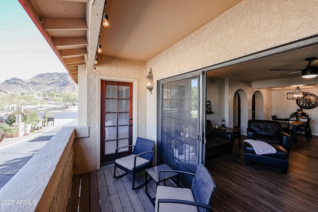 wooden deck featuring a mountain view and ceiling fan