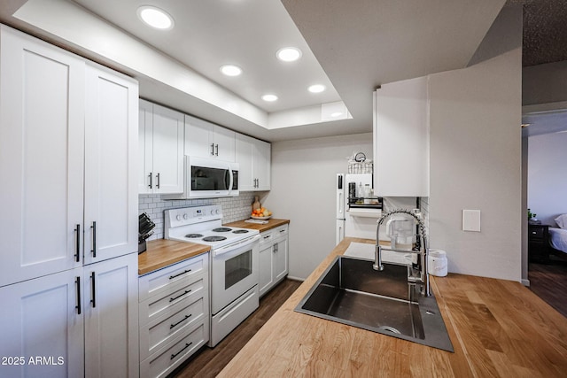 kitchen with white appliances, wood counters, white cabinetry, tasteful backsplash, and sink