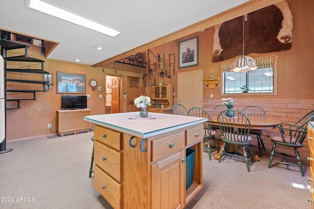 kitchen featuring light colored carpet, decorative light fixtures, and a center island