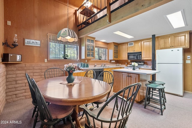 carpeted dining area with a skylight and sink