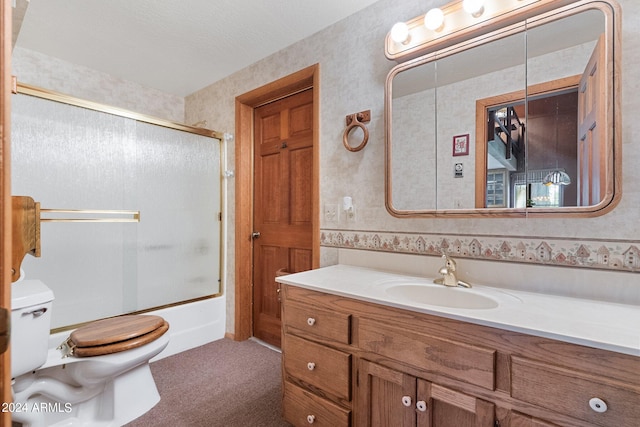 full bathroom with a textured ceiling, shower / bath combination with glass door, vanity, and toilet