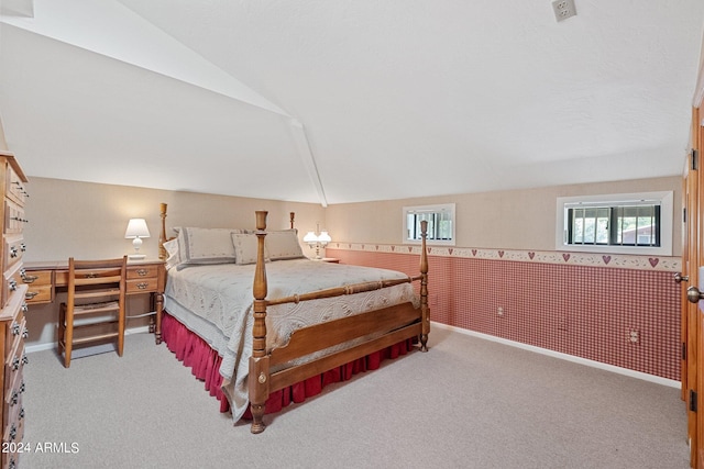 carpeted bedroom with lofted ceiling