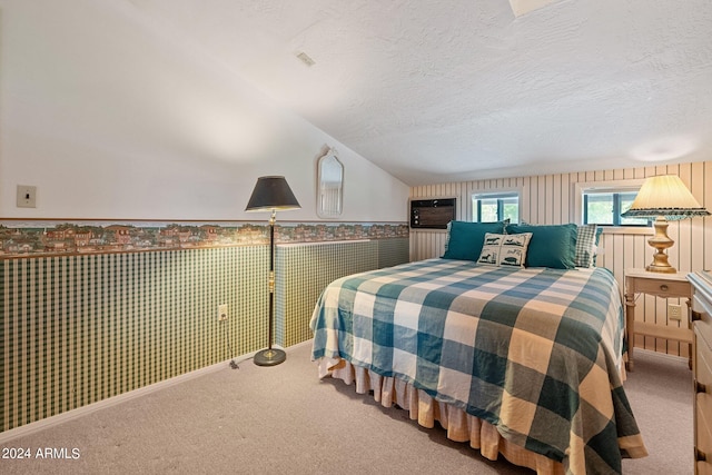 bedroom featuring vaulted ceiling, a textured ceiling, and carpet flooring