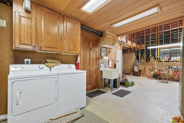 laundry area featuring wooden ceiling, washer and dryer, and cabinets