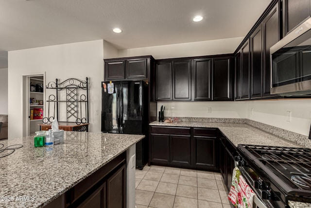 kitchen featuring light stone counters, light tile patterned floors, and stainless steel appliances