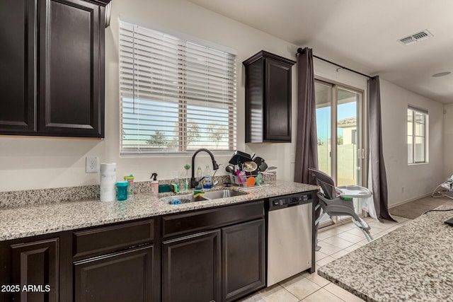 kitchen featuring light tile patterned floors, stainless steel dishwasher, a wealth of natural light, and sink