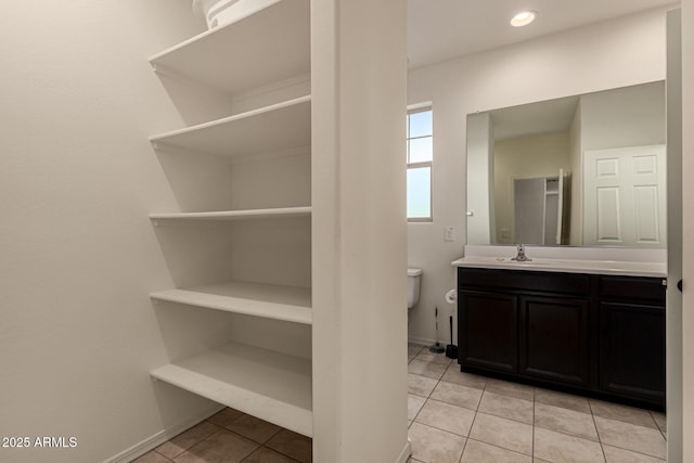 bathroom featuring tile patterned floors, vanity, and toilet