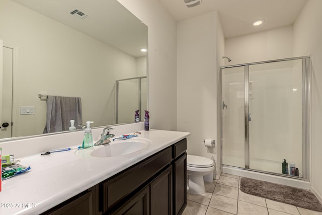 bathroom featuring tile patterned flooring, vanity, toilet, and a shower with shower door