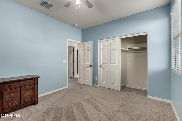 unfurnished bedroom featuring ceiling fan, light carpet, and a closet