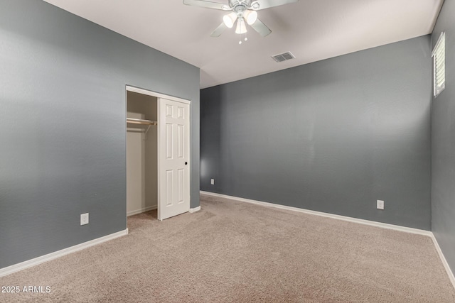 unfurnished bedroom with a closet, ceiling fan, and light colored carpet