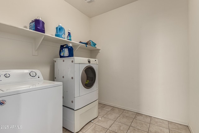 clothes washing area featuring light tile patterned floors and separate washer and dryer