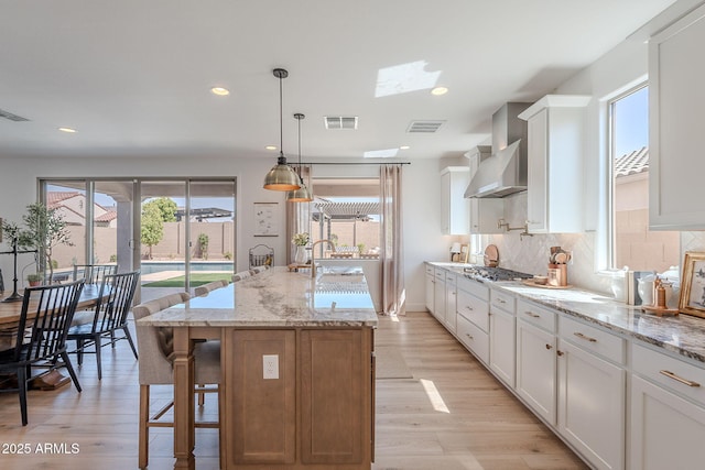 9645 E Ripple Dr, Mesa, AZ 85212 - kitchen featuring wall chimney exhaust hood, light wood-type flooring, white cabinetry, and recessed lighting