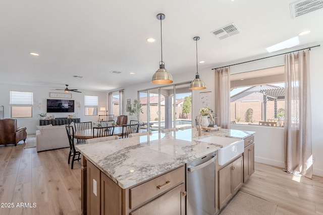 9645 E Ripple Dr, Mesa, AZ 85212 - kitchen with dishwasher, light wood-style floors, a ceiling fan, a center island with sink, and hanging light fixtures