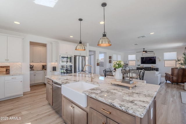 9645 E Ripple Dr, Mesa, AZ 85212 - kitchen featuring appliances with stainless steel finishes, a ceiling fan, white cabinetry, open floor plan, and backsplash