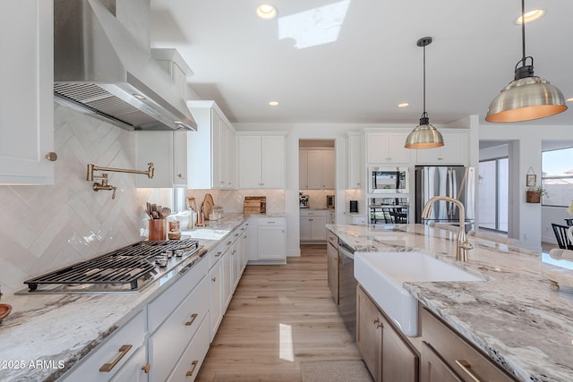 9645 E Ripple Dr, Mesa, AZ 85212 - kitchen featuring range hood, appliances with stainless steel finishes, white cabinets, decorative backsplash, and pendant lighting