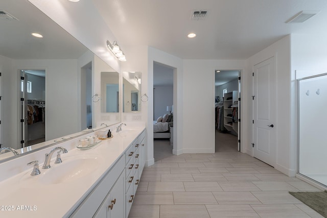 9645 E Ripple Dr, Mesa, AZ 85212 - ensuite bathroom featuring a walk in closet, double vanity, a shower stall, and recessed lighting