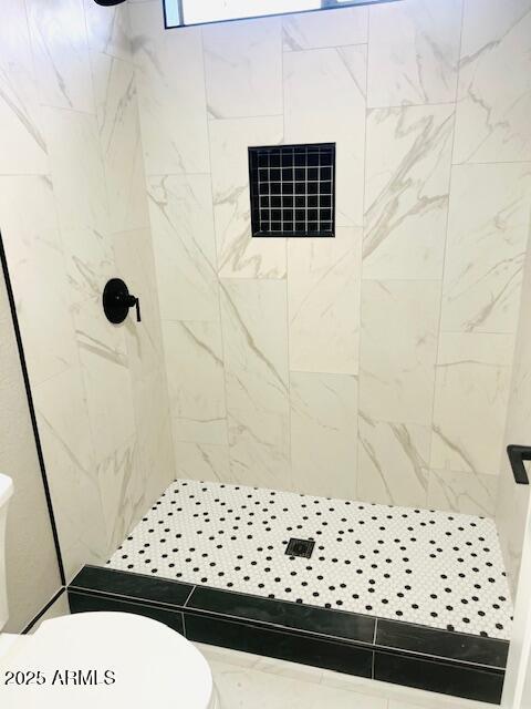 bathroom with a stall shower and toilet