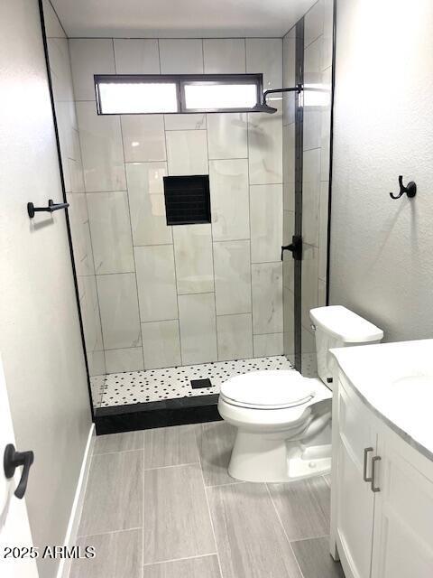 full bath with toilet, a shower stall, and vanity