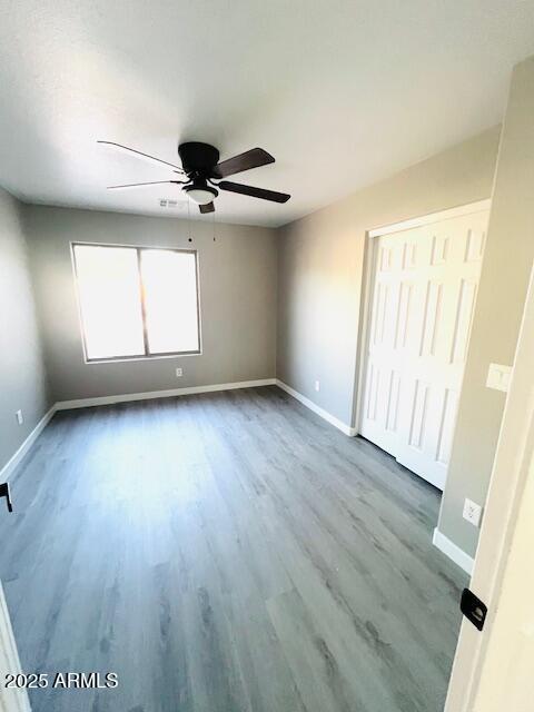 interior space featuring baseboards, wood finished floors, and ceiling fan