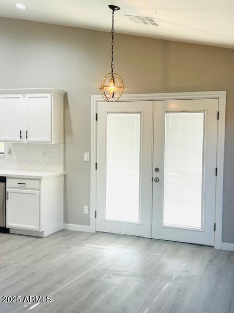 entryway featuring light wood finished floors, visible vents, french doors, and baseboards