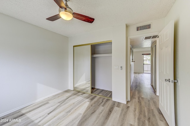 unfurnished bedroom featuring a textured ceiling, a closet, and ceiling fan