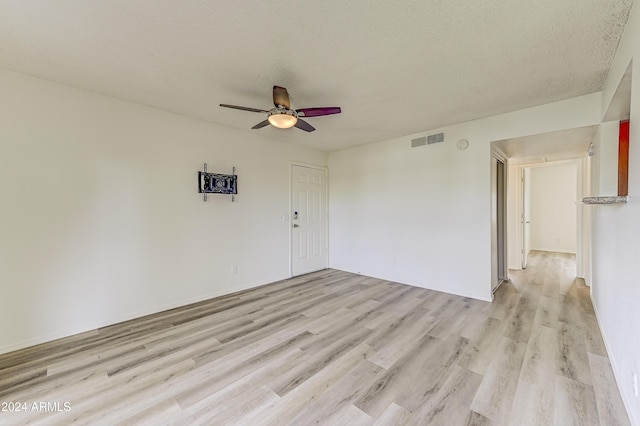 spare room with ceiling fan, a textured ceiling, and light hardwood / wood-style flooring