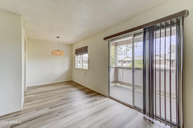 interior space with a textured ceiling and light hardwood / wood-style flooring