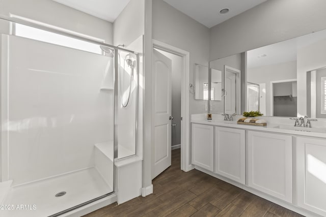 bathroom with wood-type flooring, walk in shower, and vanity