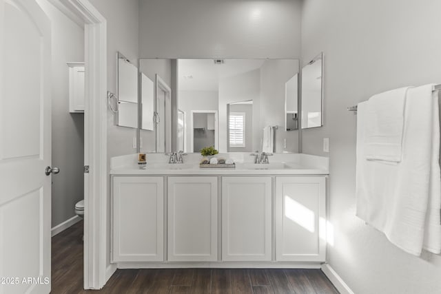 bathroom featuring toilet, wood-type flooring, and vanity