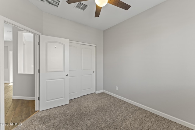 unfurnished bedroom featuring ceiling fan, a closet, and carpet flooring