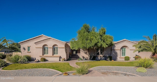 mediterranean / spanish-style house with a front lawn