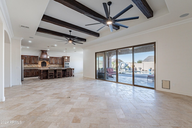 unfurnished living room with ceiling fan, beam ceiling, sink, and crown molding