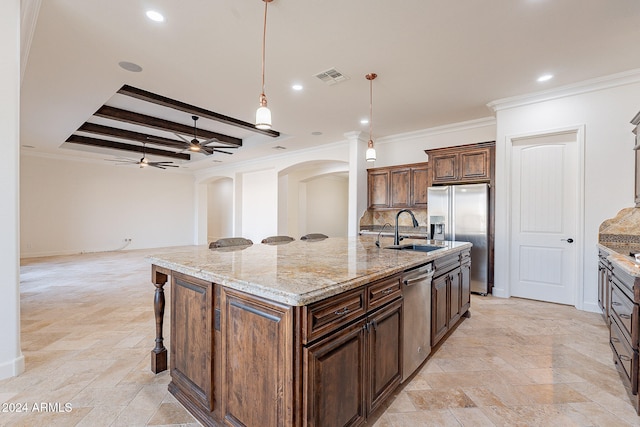 kitchen with stainless steel appliances, sink, hanging light fixtures, a kitchen island with sink, and crown molding