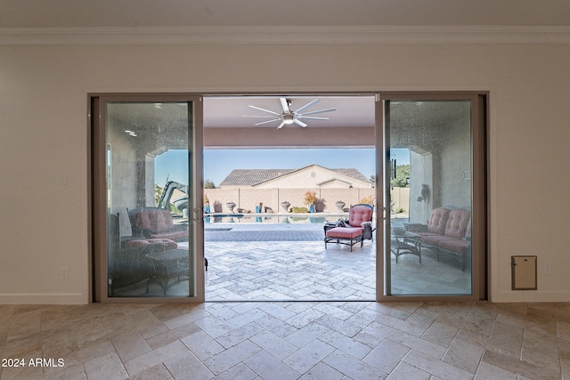 entryway featuring ceiling fan and crown molding