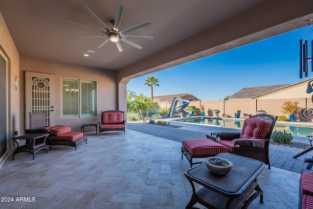 view of patio with an outdoor living space, ceiling fan, and a fenced in pool