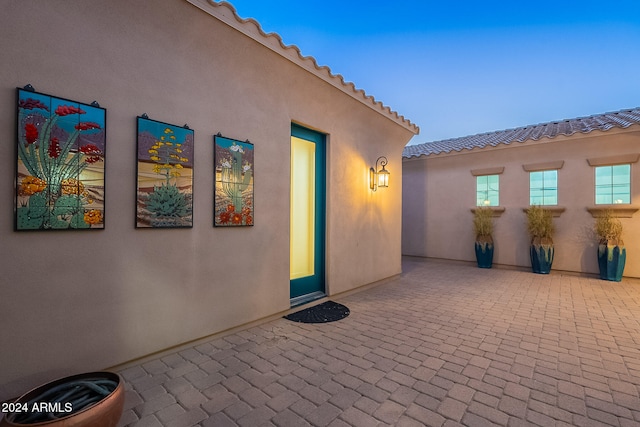 exterior entry at dusk with a patio area