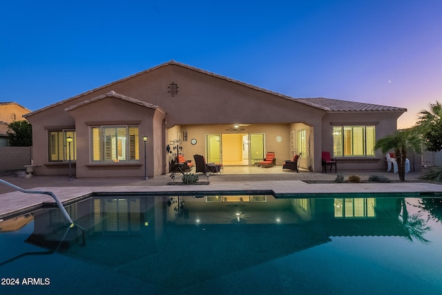 back house at dusk with a patio