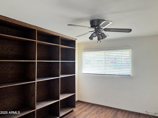 interior space featuring baseboards, dark wood finished floors, and a ceiling fan