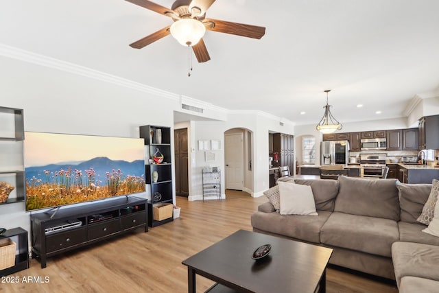 living room featuring sink, light hardwood / wood-style flooring, ornamental molding, and ceiling fan