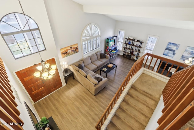 living room with an inviting chandelier, beam ceiling, high vaulted ceiling, and hardwood / wood-style flooring