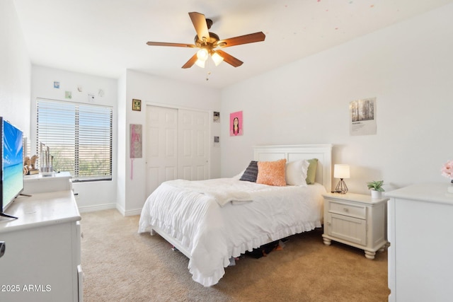 carpeted bedroom with ceiling fan and a closet