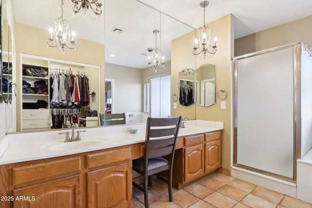 bathroom featuring vanity, tile patterned floors, a shower with door, and a chandelier