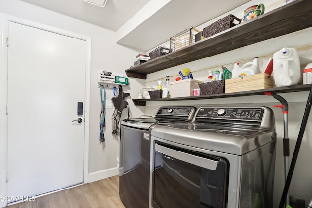 laundry room featuring washer and dryer and light hardwood / wood-style flooring