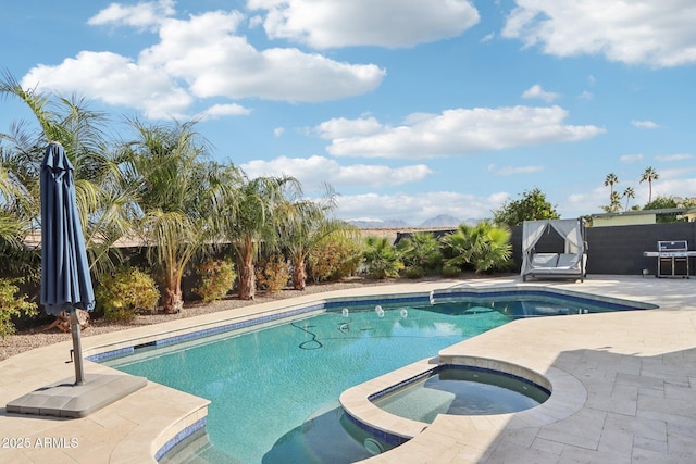 view of swimming pool with an in ground hot tub, area for grilling, and a patio